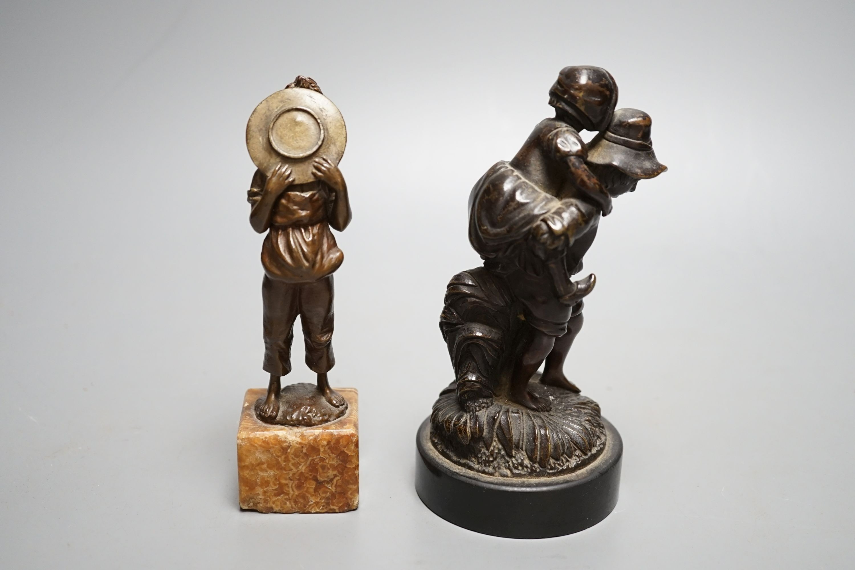 An early 20th century bronze of a boy licking a plate and a Victorian bronze group - tallest 15cm